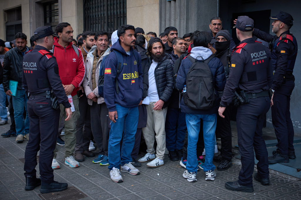 A crowd of Pakistanis gathers at the entrance of the Pakistani consulate in Barcelona, Spain, Thursday, Jan. 29, 2026, following the Spanish government's decision to grant residency and work permits to potentially hundreds of thousands of immigrants. (AP Photo/Emilio Morenatti)