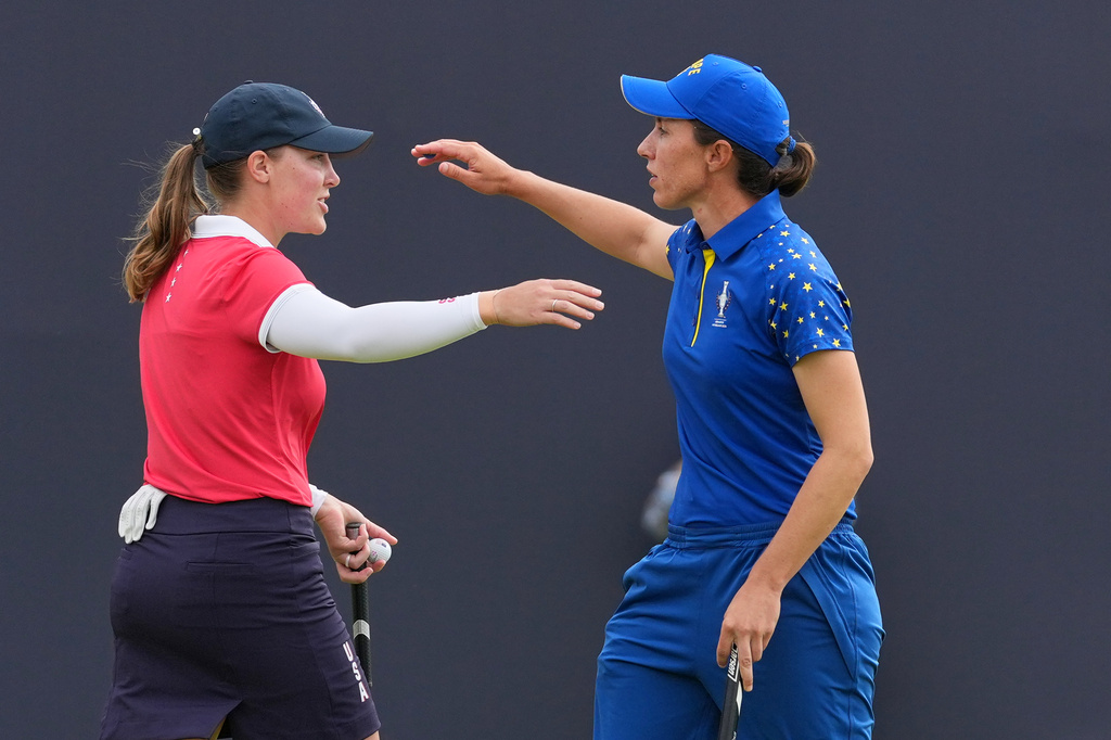 Carlota Ciganda of Europe, right, greets Jennifer Kupcho of the United States on the 16th green after winning their singles match during the final day of the Solheim Cup in Den Bosch, Netherlands, Sunday, Sept. 13, 2026. (AP Photo/Alastair Grant)