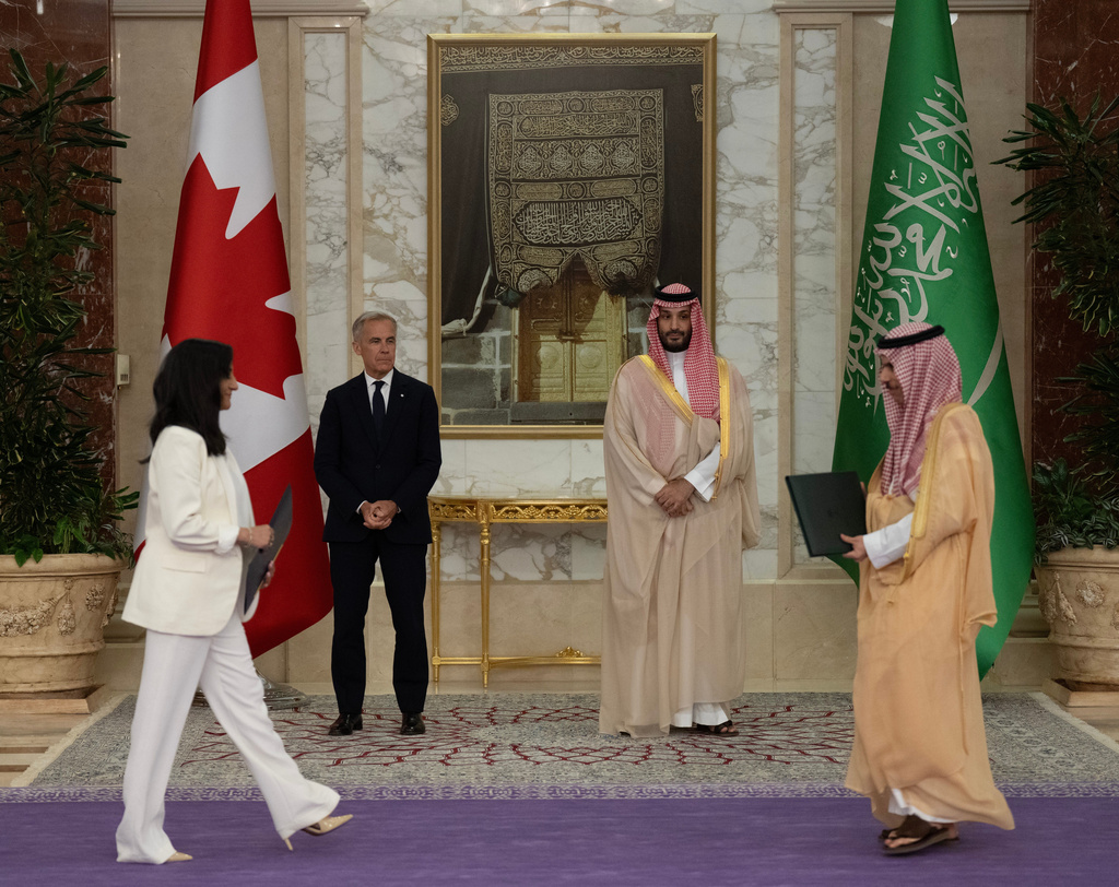Prime Minister Mark Carney, back left, and Saudi Arabia's Crown Prince Mohammed bin Salman, back right, watch the exchange of documents between Canada's Minister of Foreign Affairs Anita Anand, left, and Saudi Foreign Minister Prince Faisal bin Farhan Al Saud, right, during a signing ceremony at the Royal Palace in Jeddah, Saudi Arabia, Thursday, July 9, 2026. (Adrian Wyld/The Canadian Press via AP)