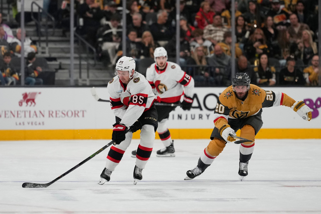 Ottawa Senators defenseman Jake Sanderson (85) skates the puck against Vegas Golden Knights left wing Brandon Saad (20) during the first period of an NHL hockey game Wednesday, Nov. 26, 2025, in Las Vegas. (AP Photo/Lucas Peltier)