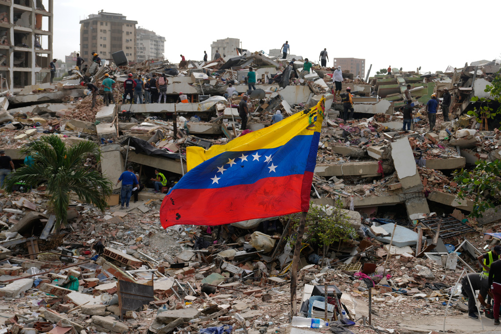 Residents and rescue workers search through the rubble of buildings damaged in the earthquakes that struck La Guaira, Venezuela, Thursday, July 2, 2026. (AP Photo/Ariana Cubillos)
