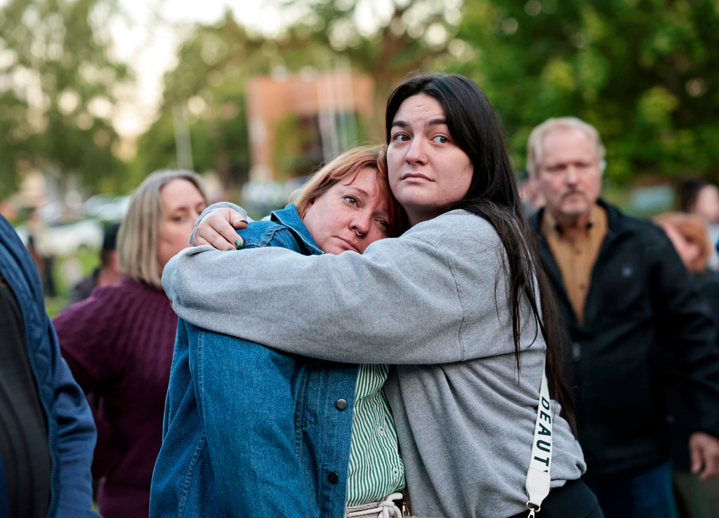 Diana Winther, left, and Kellie Webber, embrace during an evening prayer and vigil in support for the victims and their families impacted by Nippon Dynawave Packaging Co. tank implosion, at R.A. Long Park in Longview, Wash., on Tuesday, May 26, 2026. (Karen Ducey/The Seattle Times via AP)