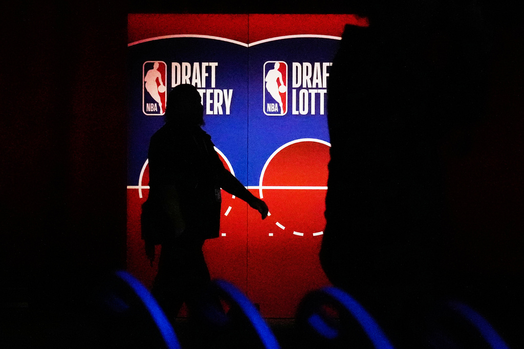 A person walks by a sign in the NBA basketball draft lottery in Chicago, Sunday, May 10, 2026. (AP Photo/Nam Y. Huh)