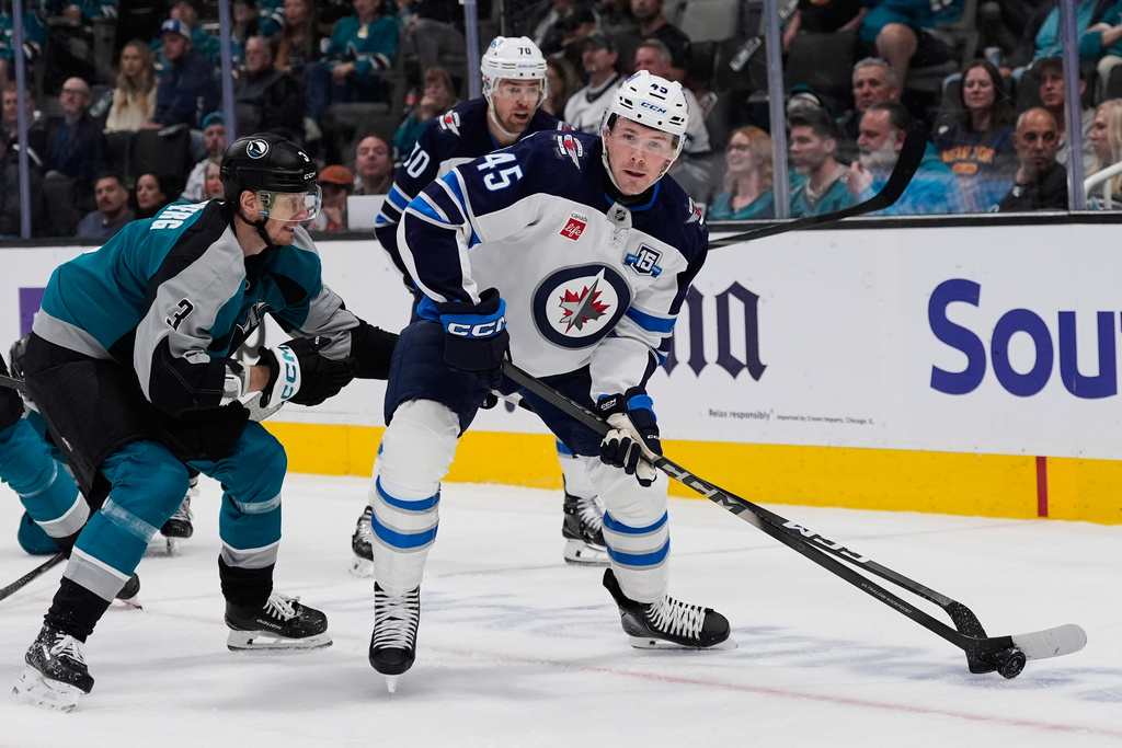 Winnipeg Jets left wing Cole Koepke (45) moves the puck while defended by San Jose Sharks defenseman John Klingberg (3) during the second period of an NHL hockey game, Sunday, March 1, 2026, in San Jose, Calif. (AP Photo/Godofredo A. Vásquez)