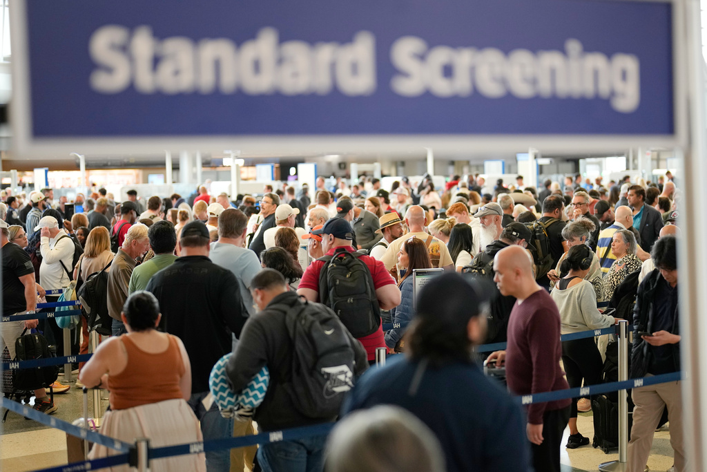 Passengers wait in a security checkpoint line at George Bush Intercontinental Airport, Wednesday, March 25, 2026, in Houston. (AP Photo/David J. Phillip)