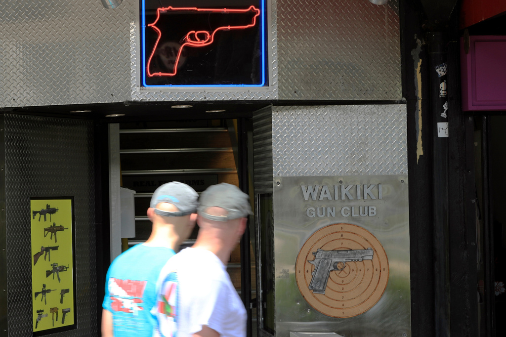 FILE - People walk past a gun club in Honolulu, June, 23, 2022. (AP Photo/Marco Garcia, File)