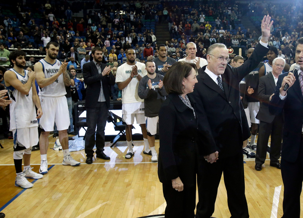 FILE - Minnesota Timberwolves head coach Rick Adelman, right, waves to the crowd as players applaud after he becomes the eighth coach in the NBA to win 1,000 games after defeating the Detroit Pistons in their basketball game, April 6, 2013, in Minneapolis. (AP Photo/Jim Mone, File)