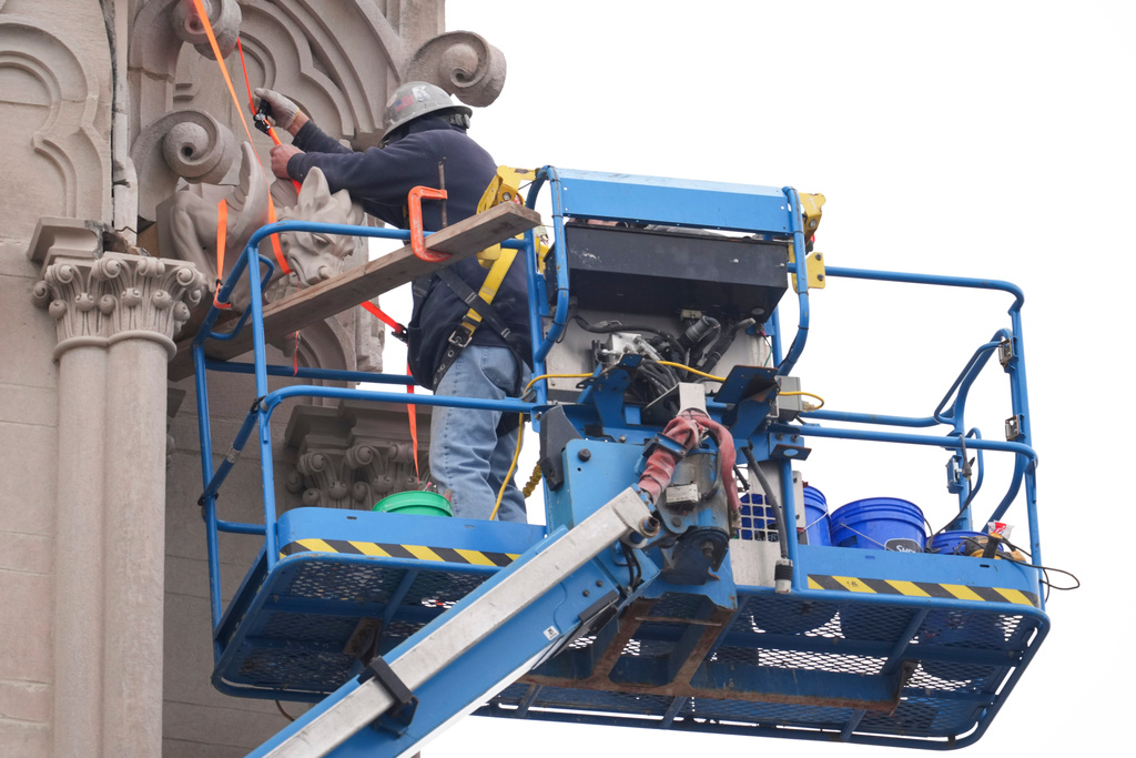 Workers install gargoyles on the Cathedral Basilica of the Assumption, Thursday, Jan. 8, 2026, in Covington, Kentucky. (AP Photo/Jeff Dean)