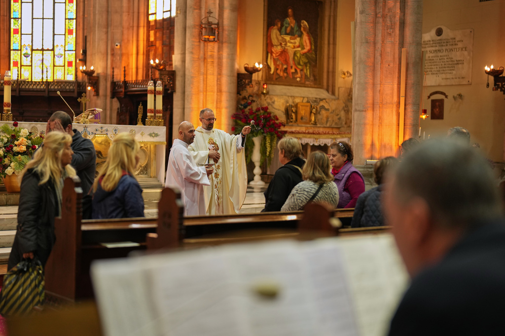 Christian Catholic priest Father Andrew, center, blesses worshippers during a mass at St. Anthony of Padua Catholic church, in Istanbul, Turkey, Tuesday, Nov. 18, 2025, ahead of the visit of Pope Leo XIV to Turkey. (AP Photo/Francisco Seco)
