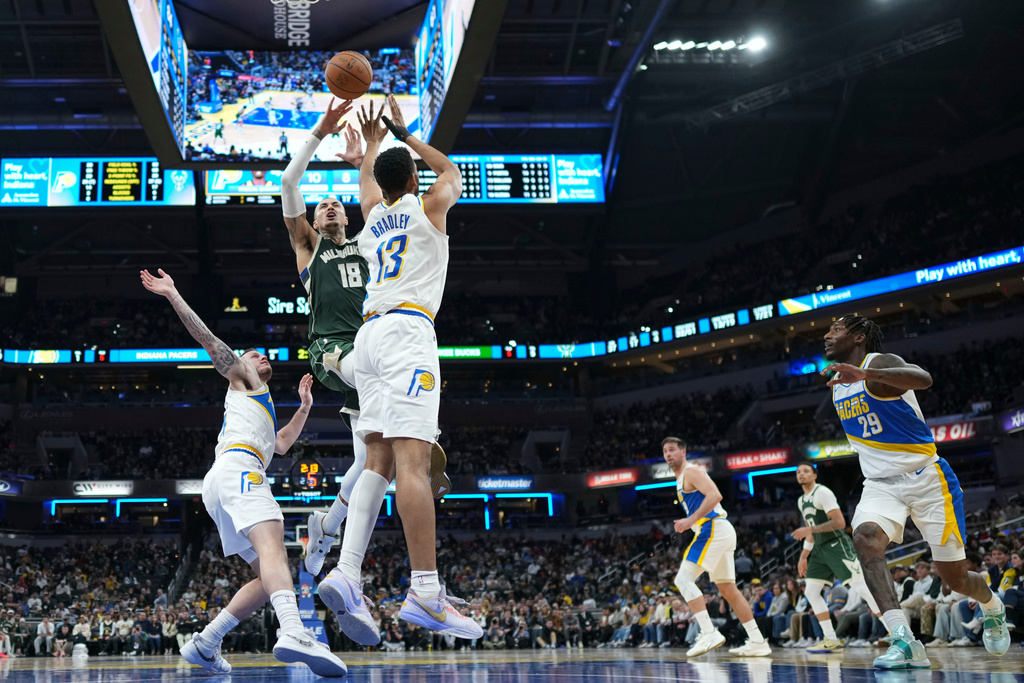 Milwaukee Bucks forward Kyle Kuzma (18) shoots over Indiana Pacers center Tony Bradley (13) during the second half of an NBA basketball game in Indianapolis, Tuesday, Dec. 23, 2025. (AP Photo/AJ Mast)