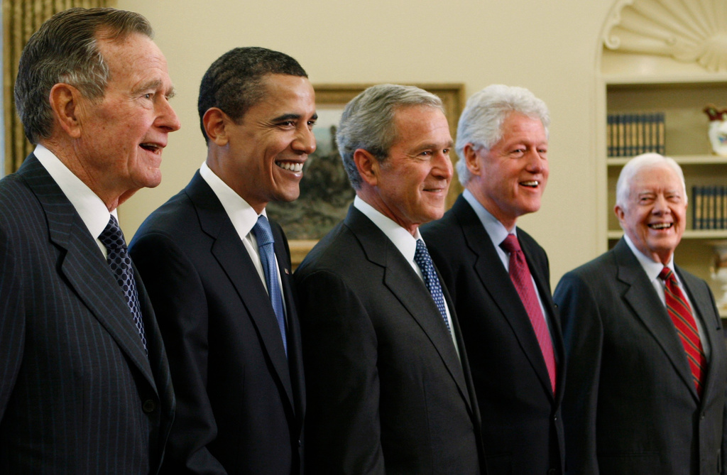 FILE - President George W. Bush, center, poses with President-elect Barack Obama, and former presidents, from left, George H.W. Bush, left, Bill Clinton and Jimmy Carter, right, Jan. 7, 2009, in the Oval Office of the White House in Washington. (AP Photo/J. Scott Applewhite, File)