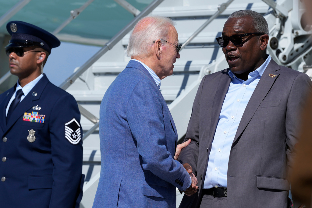 FILE - President Joe Biden, center, greets Virgin Islands Gov. Albert Bryan, Jr., right, before boarding Air Force One at Henry E. Rohlsen Airport in Christiansted, St. Croix, U.S. Virgin Islands, Dec. 31, 2024. (AP Photo/Susan Walsh, File)