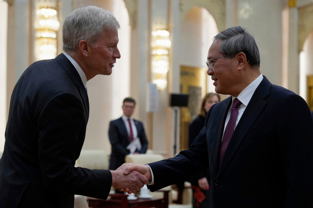 FILE-Chinese Premier Li Qiang, right, greets Cargill CEO Brian Sikes, from a delegation led by U.S. Senator Steve Daines before a meeting held in the Fujian Room at the Great Hall of the People in Beijing, China, Sunday, March 23, 2025. (AP Photo/Ng Han Guan, Pool, File)