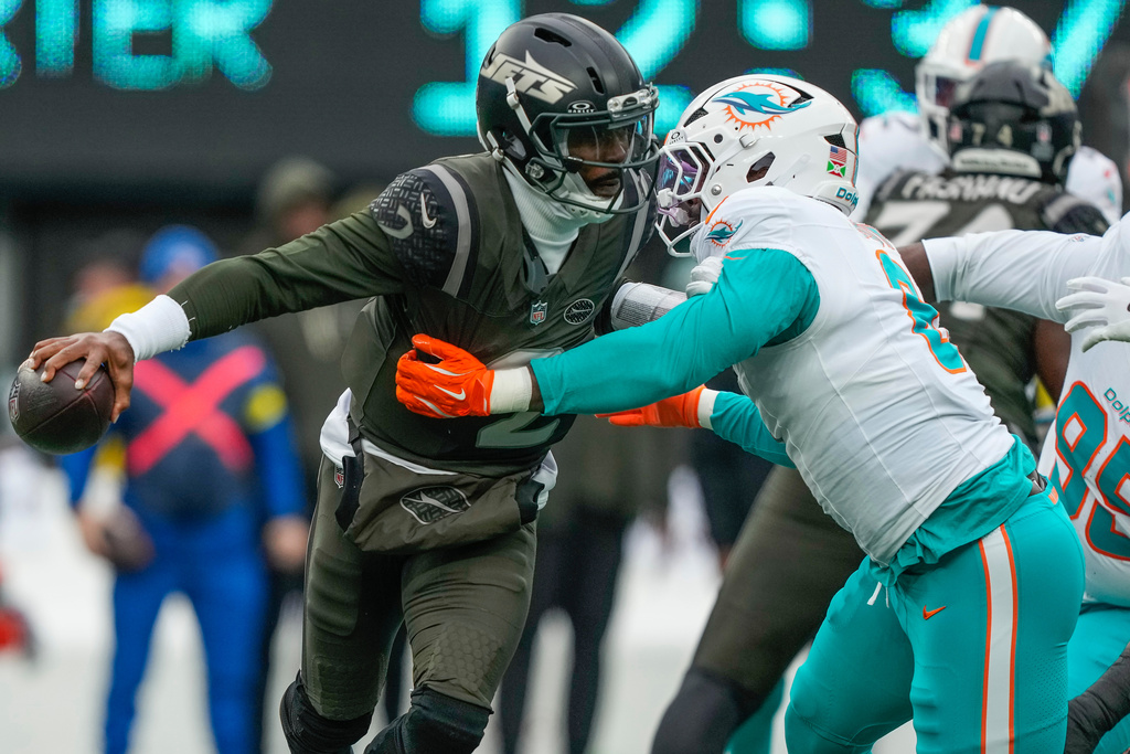 New York Jets quarterback Tyrod Taylor (2) avoids a sack by DUPLICATE***Miami Dolphins outside linebacker Matthew Judon (8) during the first quarter of an NFL football game, Sunday, Dec. 7, 2025, in East Rutherford, N.J. (AP Photo/Yuki Iwamura)