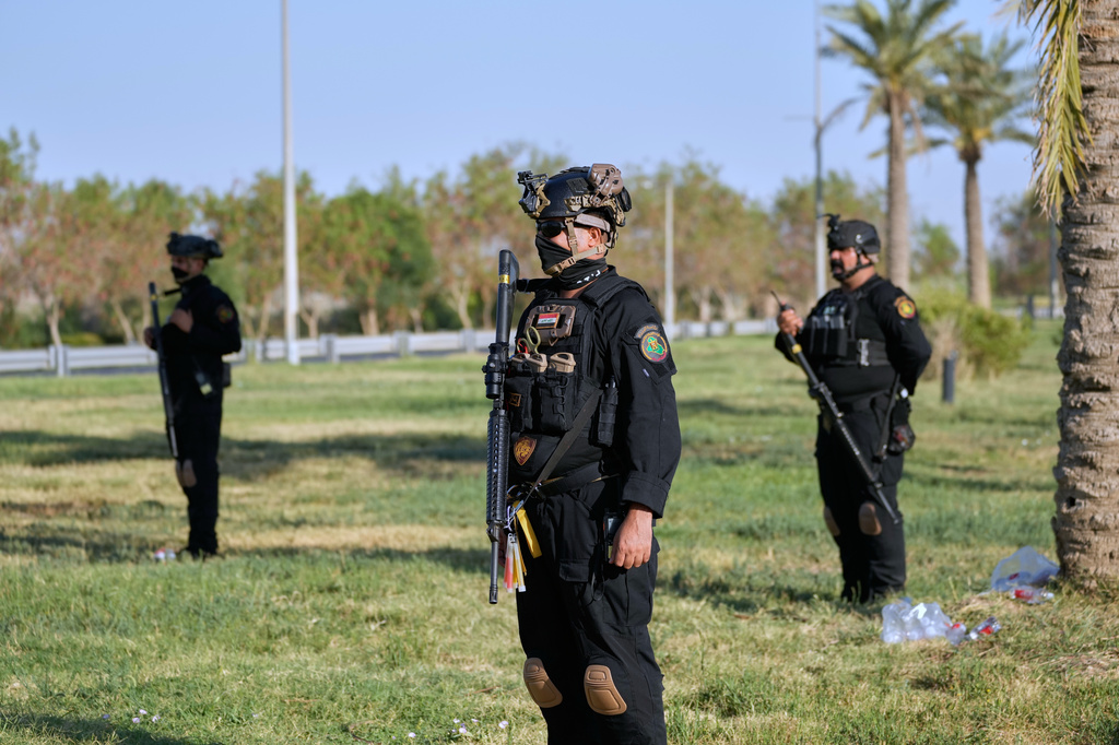 Iraqi security officers stand guard at the site near Baghdad International Airport where Iranian military commander Qassem Soleimani was killed in a U.S. drone strike, during a visit by Iranian Parliament Speaker Mohammad Baqer Qalibaf in Baghdad, Iraq, Wednesday, Aug. 19, 2026. (AP Photo/Hadi Mizban)