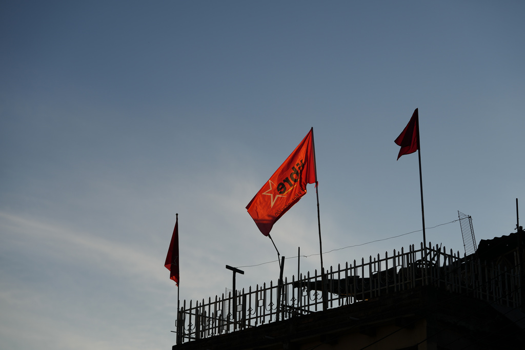 Flags of the ruling party LIBRE, Liberty and Refoundation, fly on a home's roof in Tegucigalpa, Honduras, Tuesday, Dec. 2, 2025. (AP Photo/Moises Castillo)
