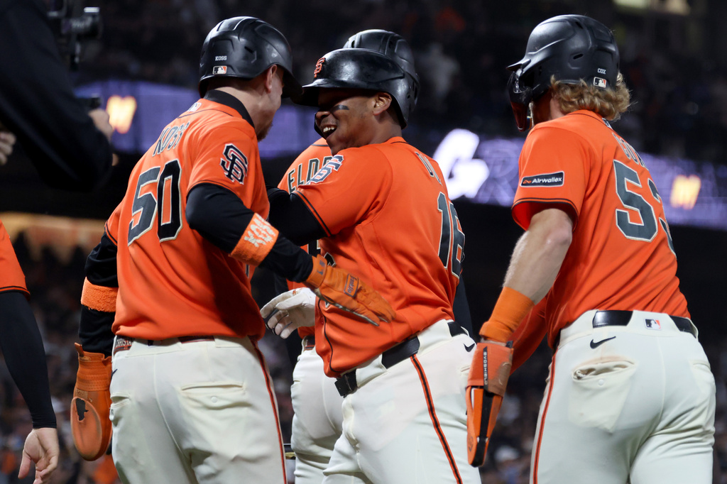 San Francisco Giants' Rafael Devers, center, celebrates with Christian Koss, left, and Jonah Cox, right, after hitting a grand slam during the fifth inning of a baseball game against the San Diego Padres in San Francisco, Friday, Sept. 11, 2026. (AP Photo/Jed Jacobsohn)