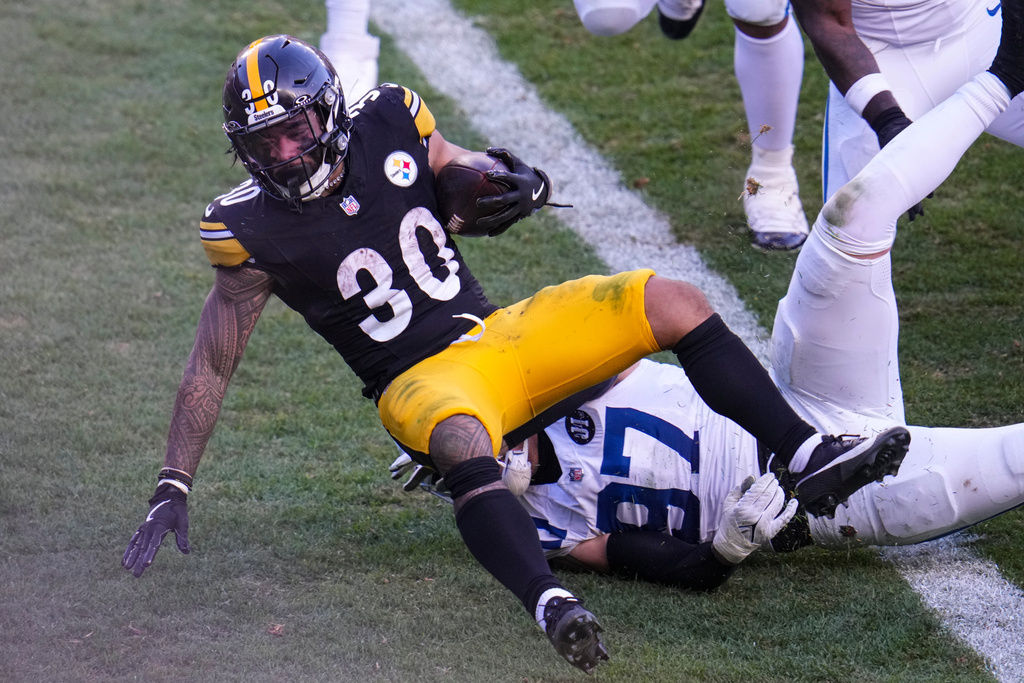 Pittsburgh Steelers running back Jaylen Warren (30) goes over Indianapolis Colts defensive end Laiatu Latu (97) on his way to a touchdown during the second half of an NFL football game in Pittsburgh, Sunday, Nov. 2, 2025. (AP Photo/Gene J. Puskar)