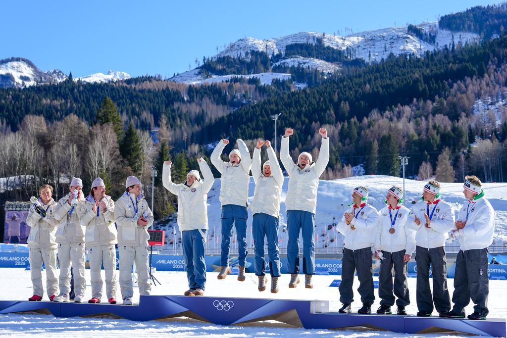 Gold medalists Norway celebrate on the podium flanked by silver medalists France, left, and bronze medalists Italy after the cross country skiing men's 4 x 7.5km relay at the 2026 Winter Olympics, in Tesero, Italy, Sunday, Feb. 15, 2026. (AP Photo/Kirsty Wigglesworth)