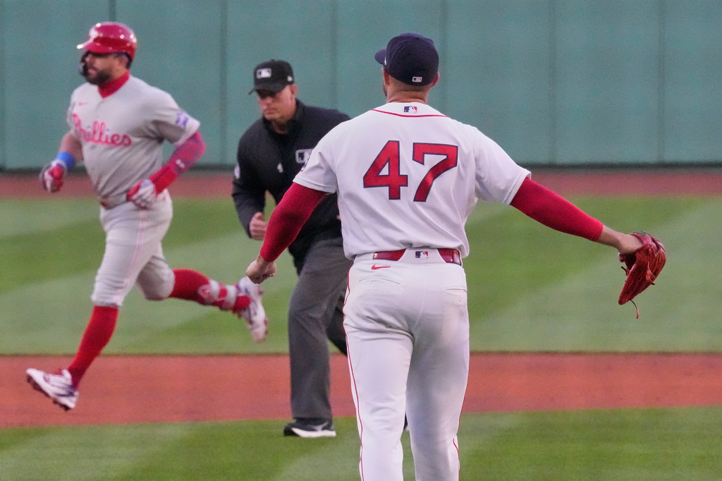Boston Red Sox pitcher Jovani Moran (47) watches Philadelphia Phillies designated hitter Kyle Schwarber rounds the bases on a solo home run during the first inning of a baseball game, Tuesday, May 12, 2026, in Boston. (AP Photo/Charles Krupa)