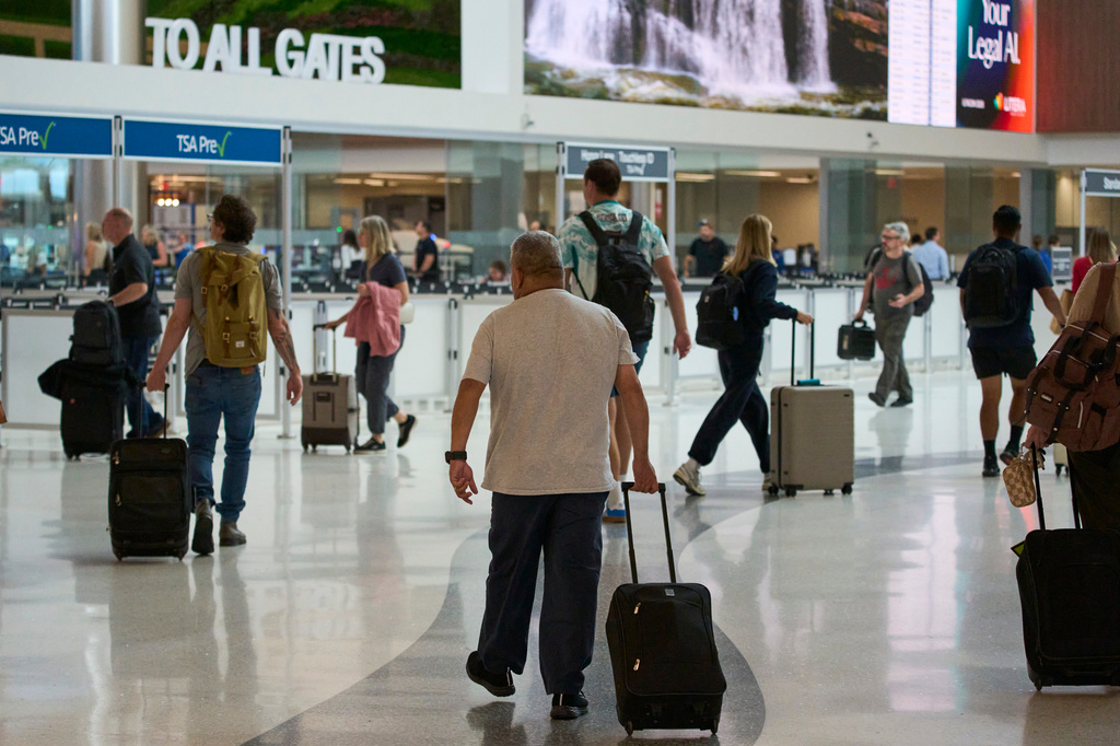 Travelers make their way through Nashville International Airport, Friday, Aug. 28, 2026, in Nashville, Tenn. (AP Photo/George Walker IV)
