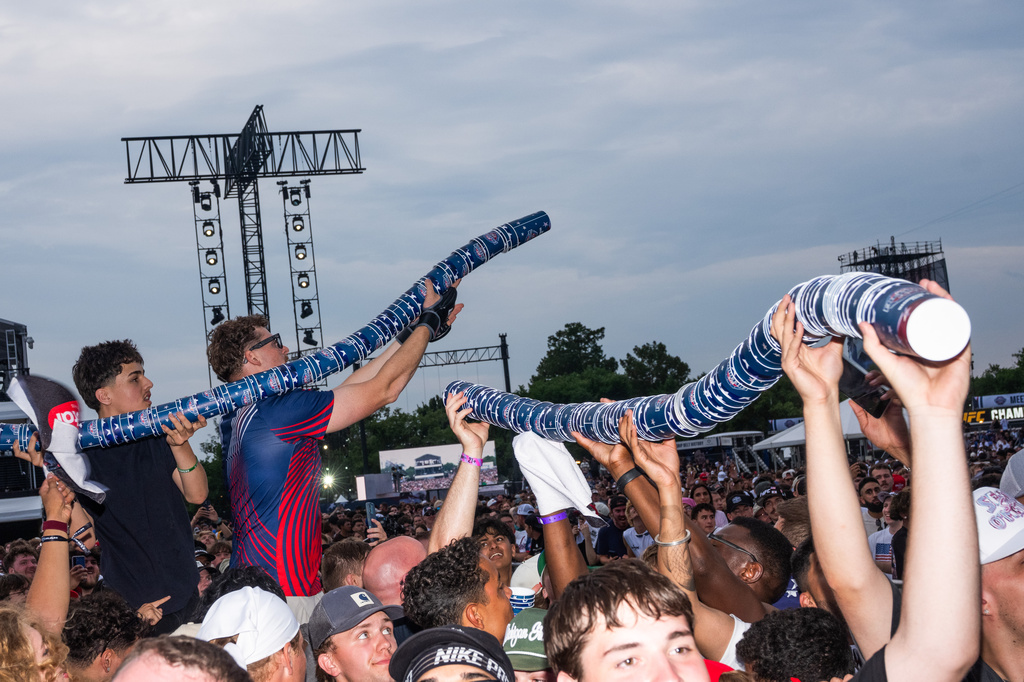 Attendees make a stack of cups at the UFC Fan Fest on the White House Ellipse ahead of the fights on the South Lawn, Sunday, June 14, 2026, in Washington. (AP Photo/Allison Robbert)