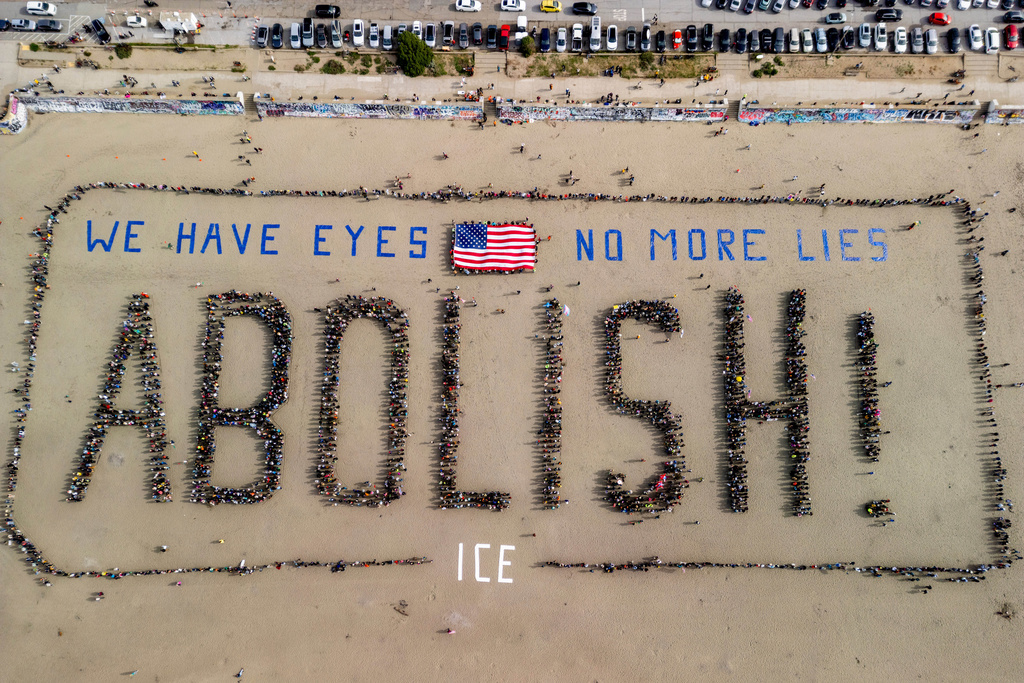 In an aerial view, protesters form a human banner on Ocean Beach during a protest amidst the ongoing nationwide federal immigration raids and unrest in Minneapolis, in San Francisco, Saturday, Jan. 31, 2026. (Stephen Lam/San Francisco Chronicle via AP)