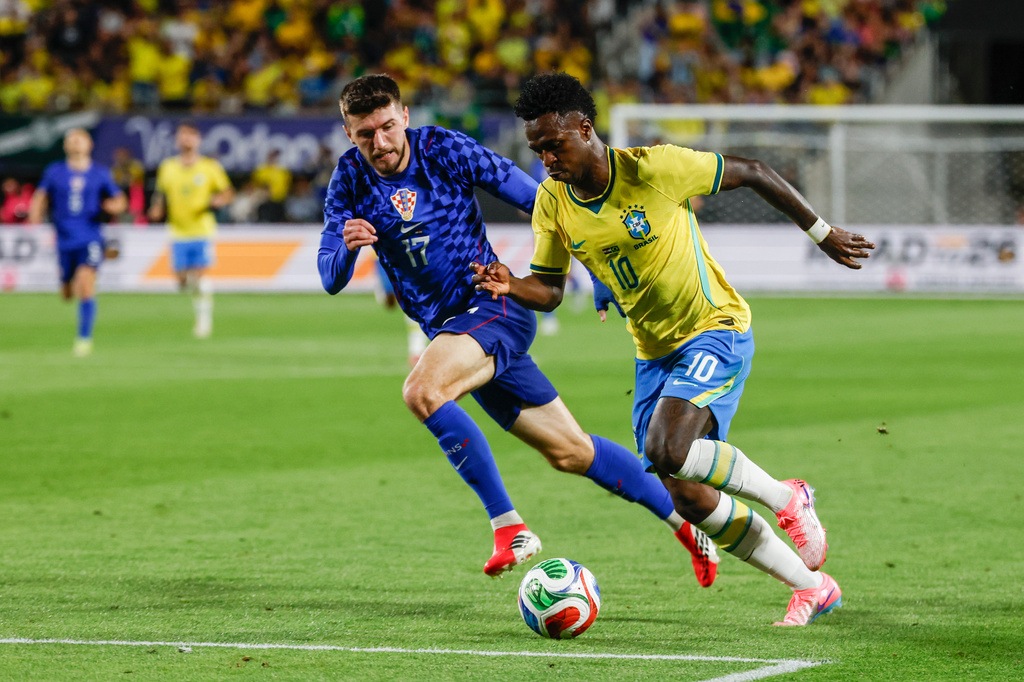 Brazil forward Vinícius Júnior (10) is defended by Croatia midfielder Petar Sucic (17) during the first half of an international friendly soccer game, Tuesday, March 31, 2026, in Orlando, Fla. (AP Photo/Kevin Kolczynski)
