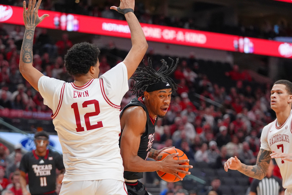 Texas Tech forward JT Toppin (15) turns to drive on Arkansas forward Malique Ewin (12) during the first half of an NCAA college basketball game, Saturday, Dec. 13, 2025, in Dallas. (AP Photo/LM Otero)