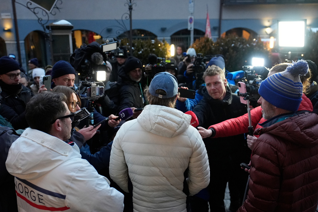Norway's Atle Lie McGrath, center with back to camera, meets the media outside his hotel following an alpine ski, men's slalom race, at the 2026 Winter Olympics, in Bormio, Italy, Monday, Feb. 16, 2026. (AP Photo/John Locher)