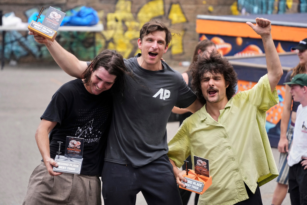 Extreme pogo athlete Michael Mena, center, celebrates his first place win in the Best Trick competition with Henry Cabelus, left, second place, and Dalton Smith, third place at Pogopalooza 2026 in Wilkinsburg, Pa., Sunday, June 14, 2026. (AP Photo/Gene J. Puskar)