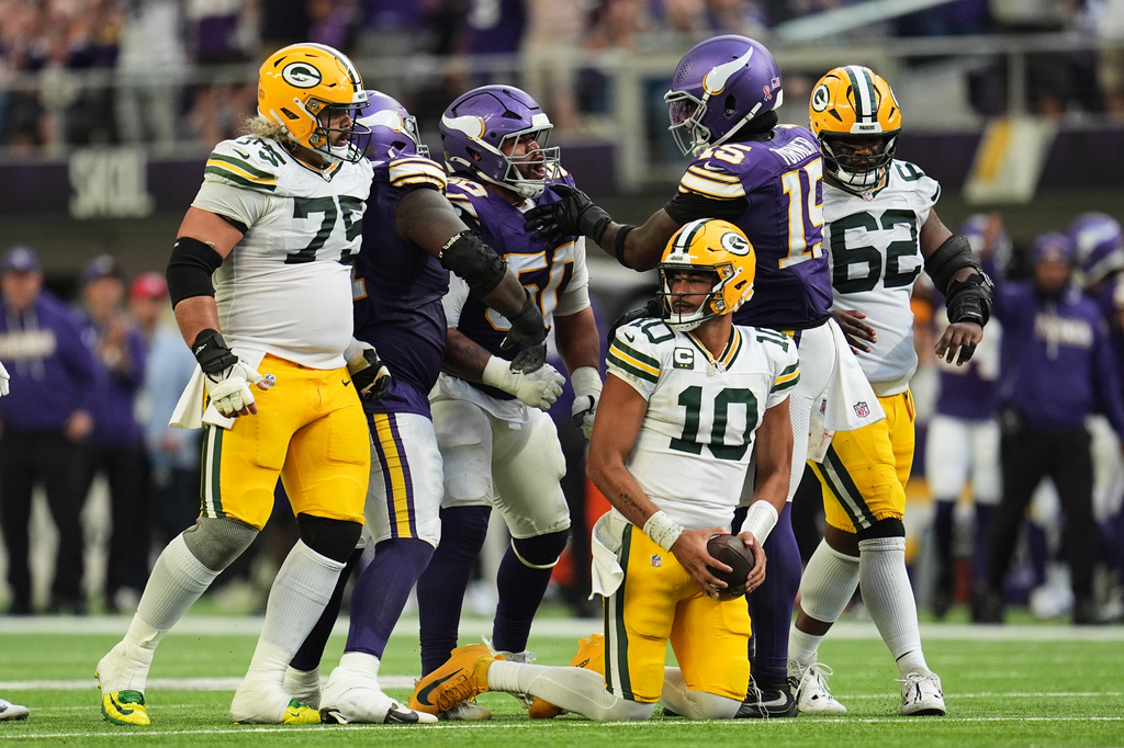 Green Bay Packers quarterback Jordan Love (10) recovers from being sacked by Minnesota Vikings' Levi Drake Rodriguez (50) who celebrates the play with Dallas Turner (15) during the second half of an NFL football game, Sunday, Sept. 13, 2026, in Minneapolis, Minn. (AP Photo/Abbie Parr)