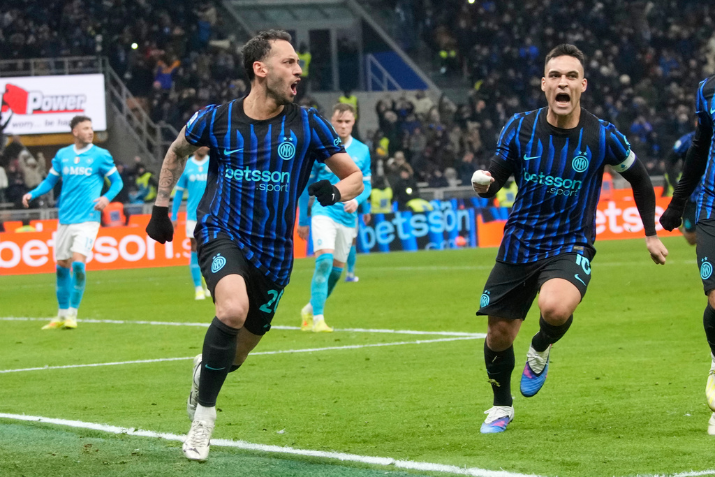 Inter Milan's Hakan Calhanoglu, centre left, celebrates with Lautaro Martinez after scoring his side's second goal during the Serie A soccer match between Inter Milan and Napoli in Milan, Italy, Sunday, Jan. 11, 2026. (AP Photo/Luca Bruno)
