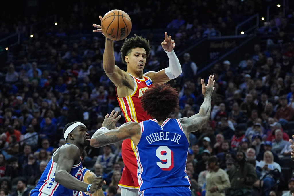 Atlanta Hawks' Jalen Johnson passes past Philadelphia 76ers' Kelly Oubre Jr. during the first half of an NBA basketball game Thursday, Feb. 19, 2026, in Philadelphia. (AP Photo/Matt Rourke)