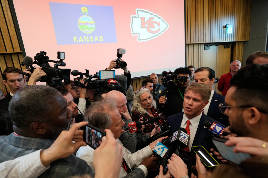 Kansas City Chiefs owner Clark Hunt, center right, talks to the media during an event Monday, Dec. 22, 2025, in Topeka, Kan., after announcing the team will leave Arrowhead Stadium in Kansas City, Mo., for a new stadium that will be built across the Kansas-Missouri state line and be ready for the start of the 2031 season. (AP Photo/Charlie Riedel)