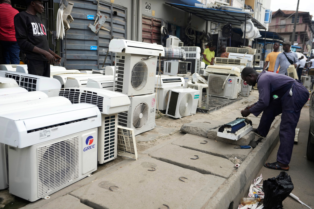 FILE - A man repairs air conditioners on the street in Lagos, Nigeria, July 15, 2024. (AP Photo/Sunday Alamba, File)