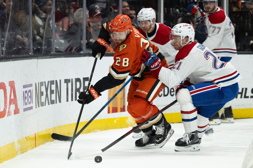 Anaheim Ducks left wing Jeffrey Viel (28) controls the puck away from Montreal Canadiens defenseman Kaiden Guhle (21) during the first period of an NHL hockey game, Friday, March 6, 2026, in Anaheim, Calif. (AP Photo/Kyusung Gong)