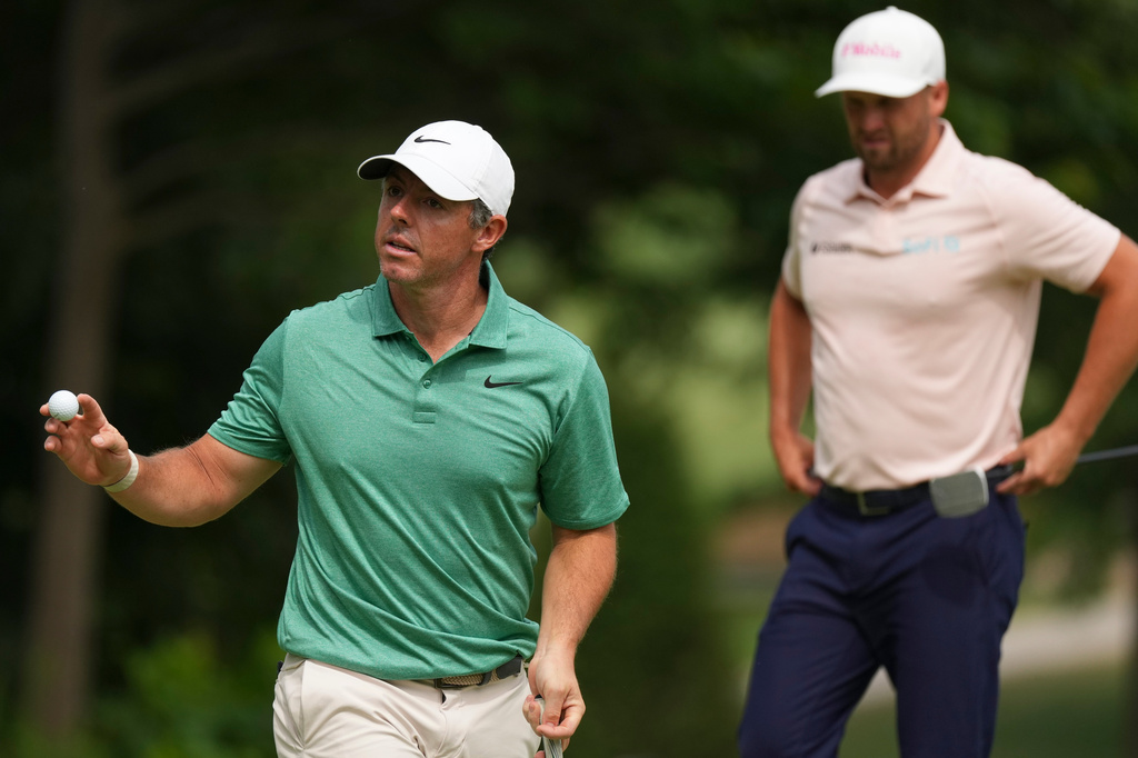 Rory McIlroy, of Northern Ireland, walks off the nineth green as Wyndham Clark is seen in the final round of the BMW Championship golf tournament, Sunday, Aug. 23, 2026, in St. Louis. (AP Photo/Jeff Roberson)