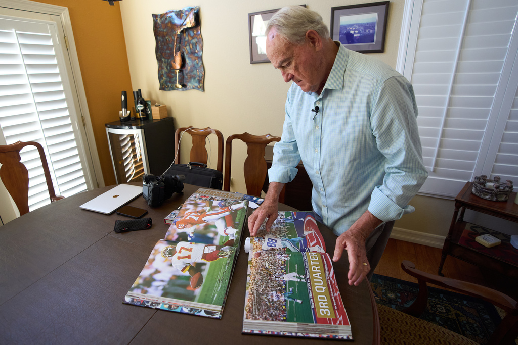 Photographer John Biever, who has shot every Super Bowl NFL football game, looks over images he has made at previous bowl games at his home Tuesday, Jan. 20, 2026, in San Diego. (AP Photo/Gregory Bull)