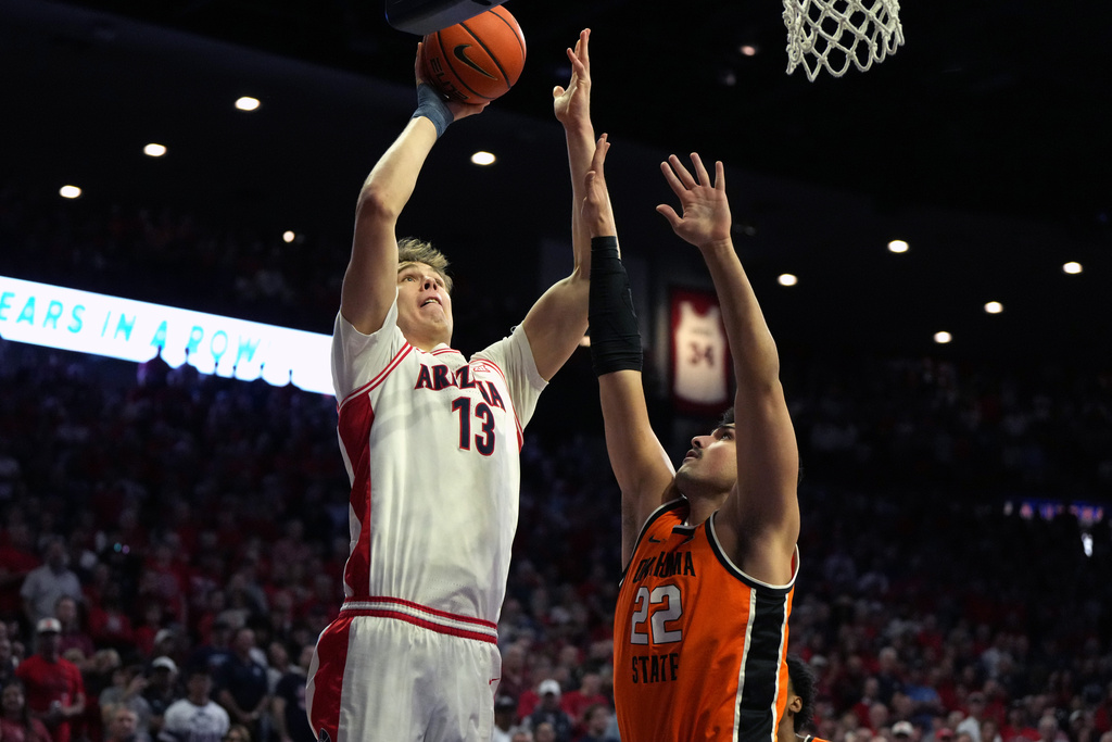 Arizona center Motiejus Krivas (13) shoots over Oklahoma State center Parsa Fallah during the first half of an NCAA college basketball game, Saturday, Feb. 7, 2026, in Tucson, Ariz. (AP Photo/Rick Scuteri)