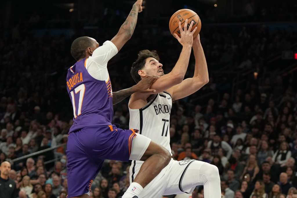 Brooklyn Nets forward Michael Porter Jr. drives on Phoenix Suns guard Jamaree Bouyea (17) during the first half of an NBA basketball game, Tuesday, Jan. 27, 2026, in Phoenix. (AP Photo/Rick Scuteri)