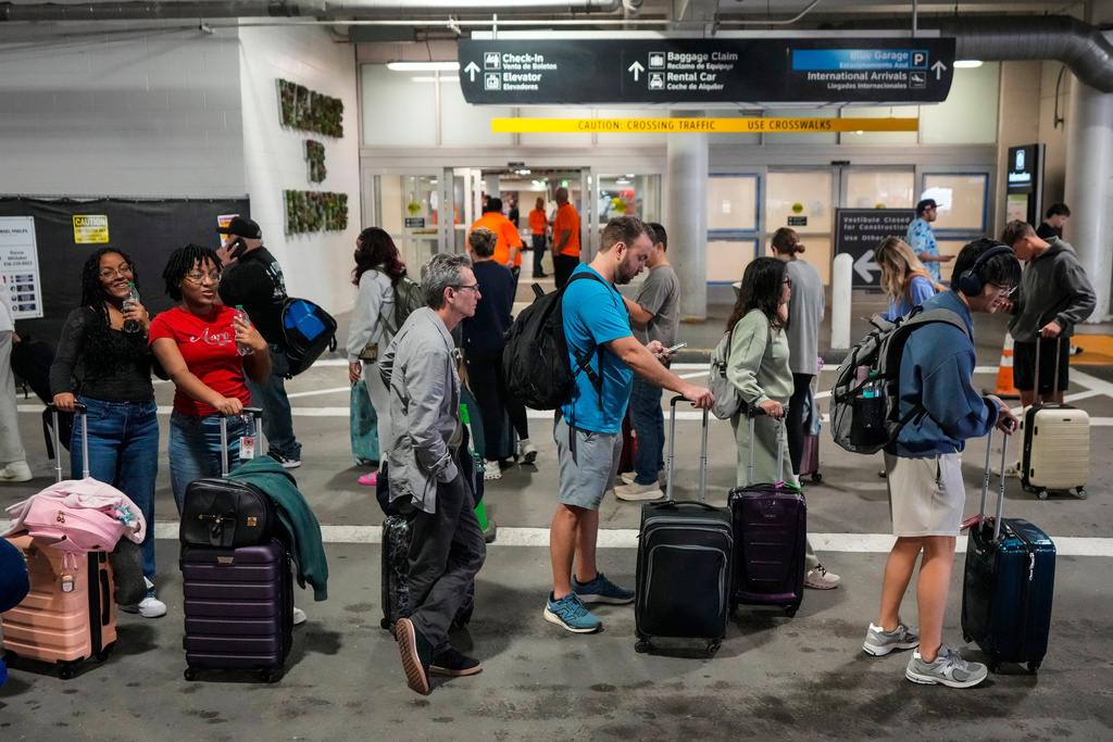 Airline passengers wait in long lines outside the terminal to get through the TSA security screening at William P. Hobby Airport in Houston, Sunday, March 8, 2026. (Brett Coomer/Houston Chronicle via AP)