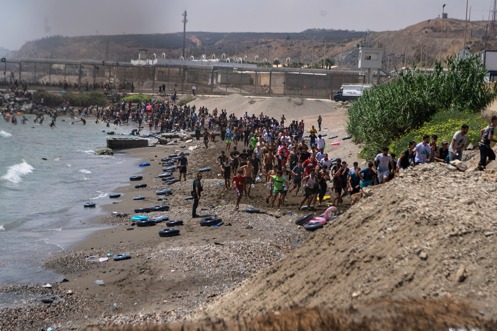 Migrants cross from Morocco into the Spanish enclave of Ceuta, Thursday, July 30, 2026. (AP Photo/Antonio Sempere)