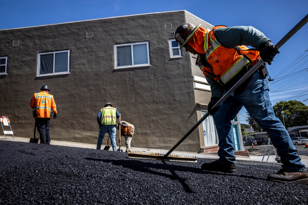 New roadway material is spread out as a paving crew with McGuire & Hester lays new asphalt, as temperatures in the bay area began to climb in Oakland, Calif., on Monday, March 16, 2026. (Carlos Avila Gonzalez/San Francisco Chronicle via AP)