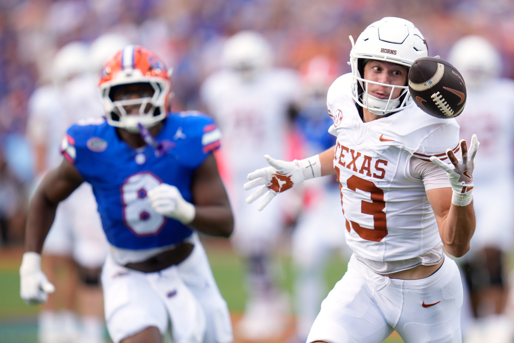 Texas wide receiver Parker Livingstone, right, makes a reception in front of Florida linebacker Aaron Chiles (8) during the first half of an NCAA college football game, Saturday, Oct. 4, 2025, in Gainesville, Fla. (AP Photo/John Raoux)