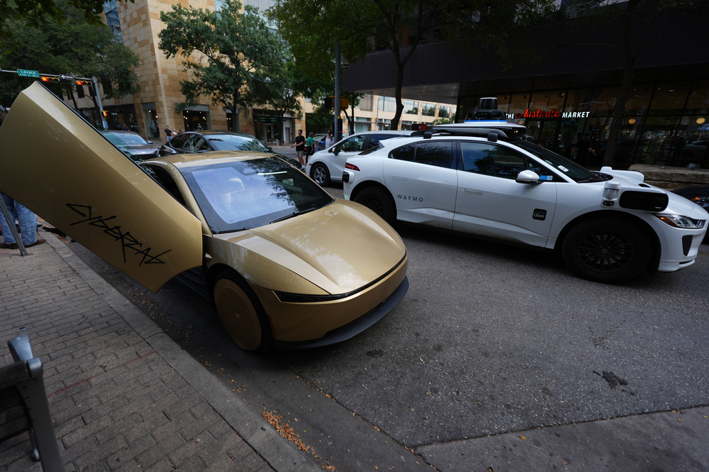A Waymo cab, right, passes a Tesla Cybercab, left, in downtown Austin, Texas, Thursday, Sept. 3, 2026. (AP Photo/Eric Gay)