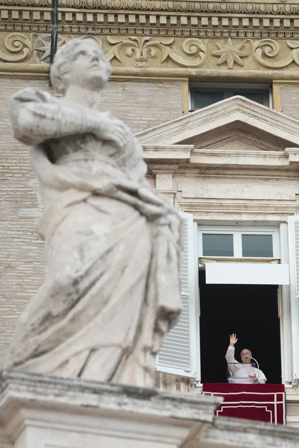 Pope Leo XIV appears at the window of his study in the Apostolic Palace overlooking St. Peter's Square at the Vatican for the traditional noon blessing after praying the Angelus, Sunday, Oct. 18, 2026, a day after he returned from the hospital, where he had lung cancer removed on Tuesday. (AP Photo/Gregorio Borgia)