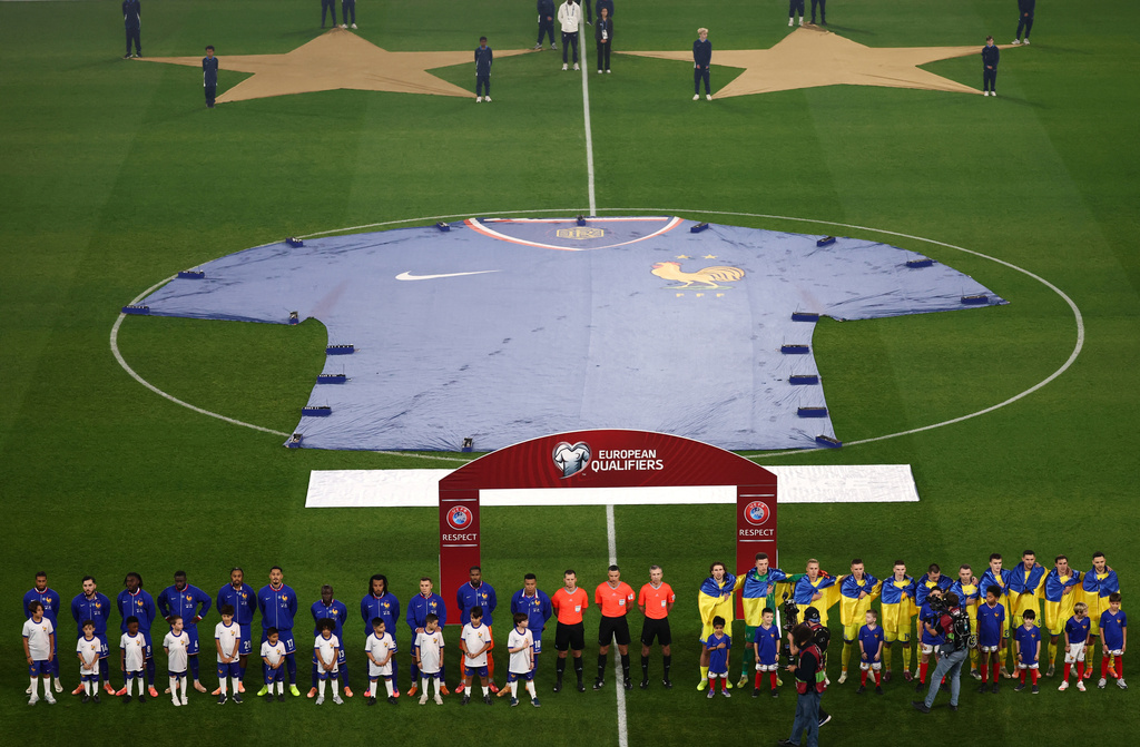 Ukraine's and France's team players stand on the pitch for the national anthems and for a minute of silence in tribute of the victims of the Nov.13, 2015 Paris attacks, ahead of the 2026 World Cup qualifiers Europe zone group D football match between France and Ukraine at the Parc des Princes stadium, Thursday, Nov. 13, 2025 in Paris. ( Franck Fife, Pool photo via AP)