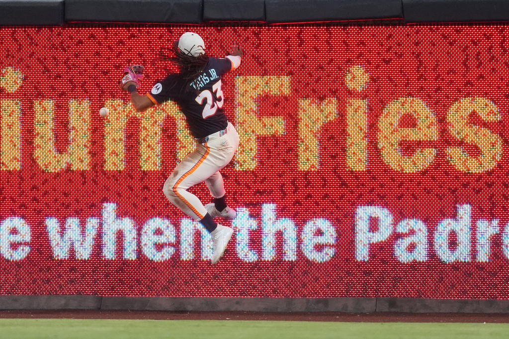 San Diego Padres right fielder Fernando Tatis Jr. leaps off the wall as he is unable to catch a hit for a two-RBI triple by Minnesota Twins' Kody Clemens during the fourth inning of a baseball game Friday, Aug. 21, 2026, in San Diego. (AP Photo/Gregory Bull)