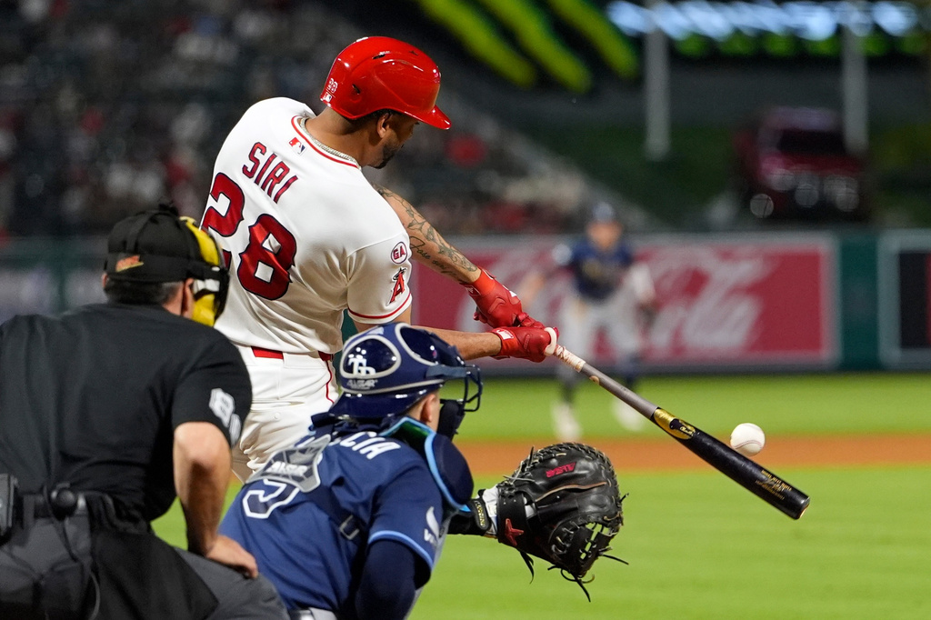 Los Angeles Angels' Jose Siri, center, hits a two-run home run as Tampa Bay Rays catcher Hunter Feduccia, right, and home plate umpire Dave Rackley watch during the seventh inning of a baseball game Saturday, June 13, 2026, in Anaheim, Calif. (AP Photo/Mark J. Terrill)